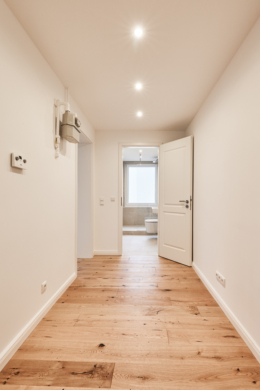 Flur mit Blick zum Badezimmer - Vollsanierte 2-Zimmerwohnung mit hochwertiger Einbauküche inkl. Elektrogeräte