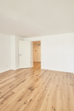 Wohnzimmer mit Blick zur Tür - Aufwendig sanierte 2-Zimmerwohnung mit großem Balkon und Einbauküche